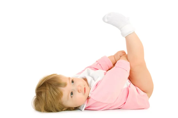 Маленький ребенок лежал на спине и сделать гимнастики — стоковое фото