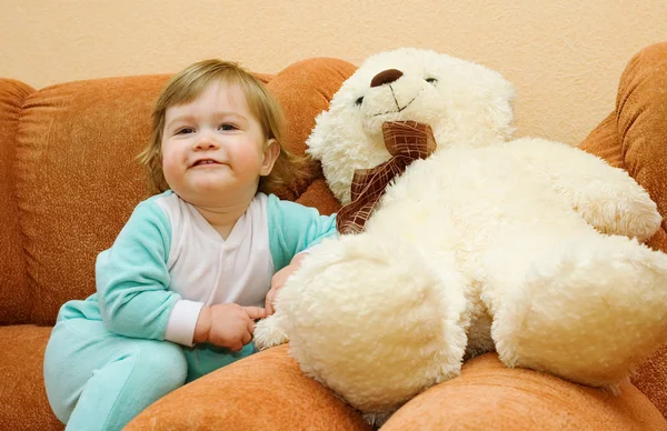 Pequeno bebê sentado em poltrona com brinquedo — Fotografia de Stock