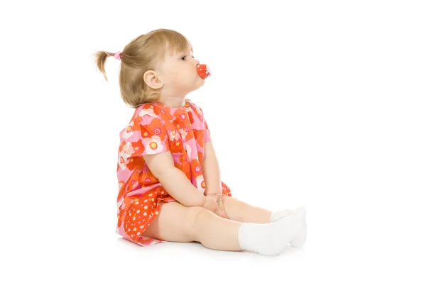Kleines lächelndes Baby im roten Kleid mit Spielzeug — Stockfoto