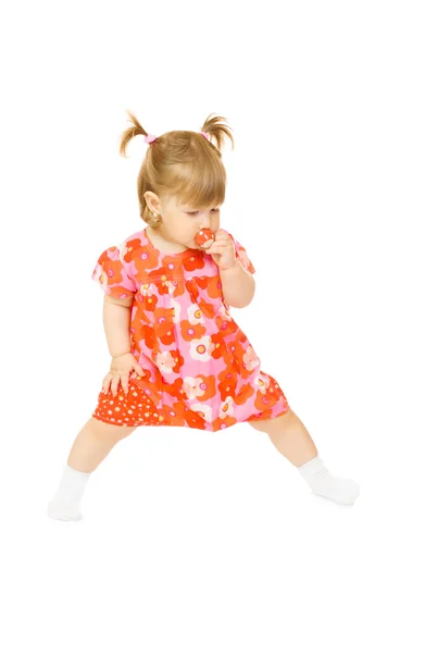 Liten leende bebis i röd klänning med leksak — Stockfoto