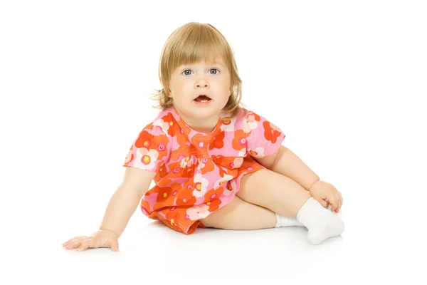 Pequeno bebê sentado em vestido vermelho isolado — Fotografia de Stock