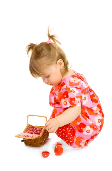 Kleines lächelndes Baby im roten Kleid mit Spielzeug — Stockfoto
