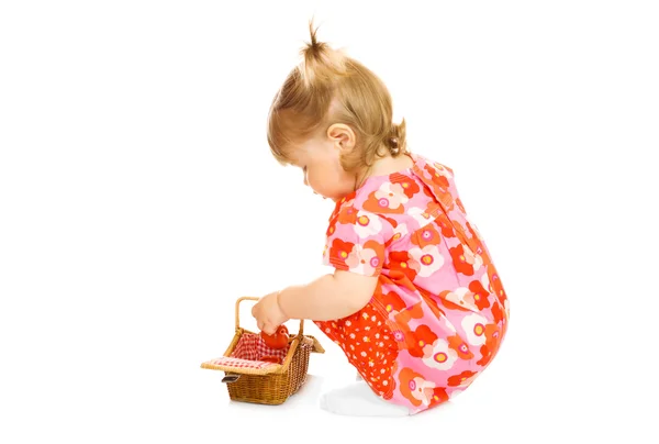 Małe dziecko w czerwonej sukience z koszyka zabawki — Zdjęcie stockowe