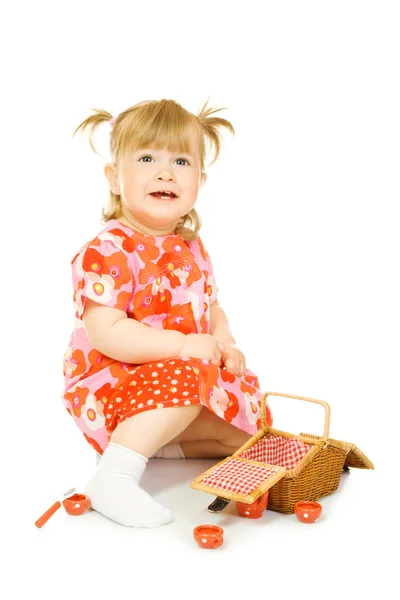 Маленький улыбающийся ребенок в красном платье с игрушкой — стоковое фото