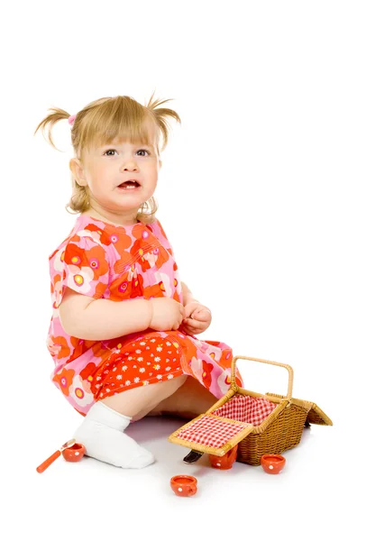 Liten leende bebis i röd klänning med leksak — Stockfoto