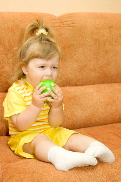 Petite fille souriante en jaune manger pomme — Photo