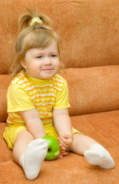 Petite fille souriante en jaune manger pomme — Photo