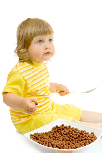 Маленька дівчинка їсть кукурудзяні пластівці — стокове фото