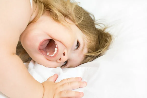 Kleines Mädchen auf einem Bett — Stockfoto