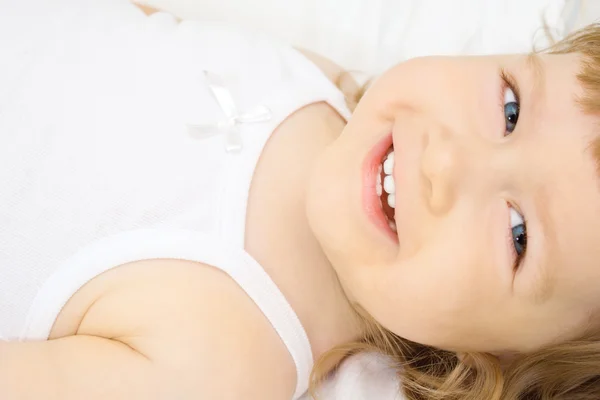 Χαμογελαστό κορίτσι σε ένα κρεβάτι — Φωτογραφία Αρχείου