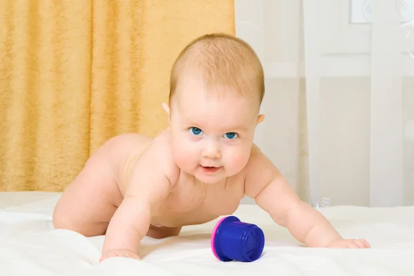 Piccolo bambino con giocattolo sul letto — Foto Stock