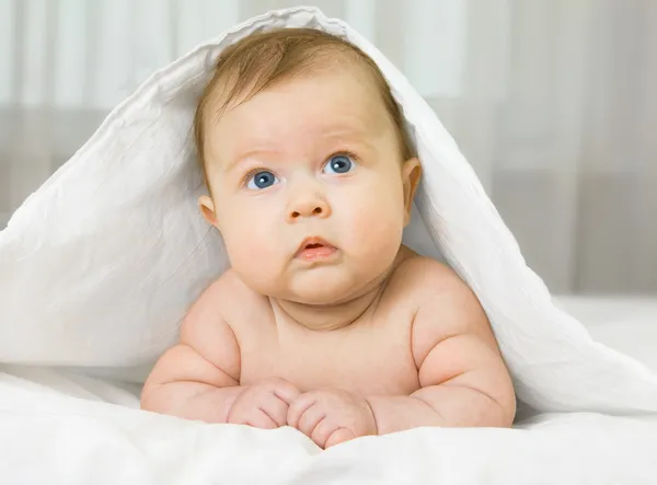 침대에 작은 웃는 아기 — 스톡 사진