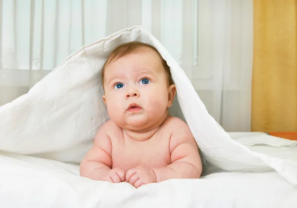 Liten leende bebis på sängen — Stockfoto