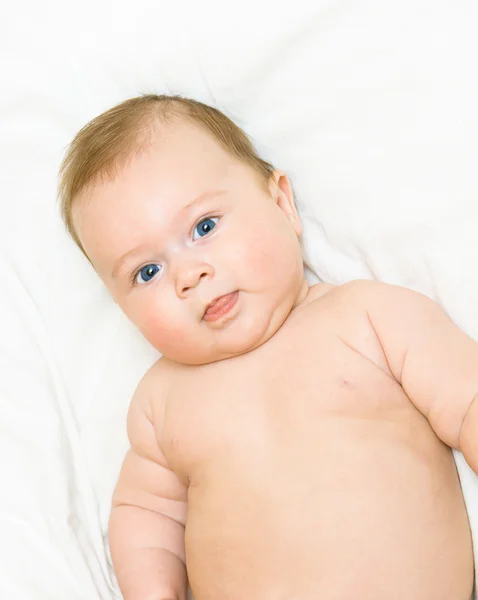 Pequeño bebé sonriente en la cama —  Fotos de Stock