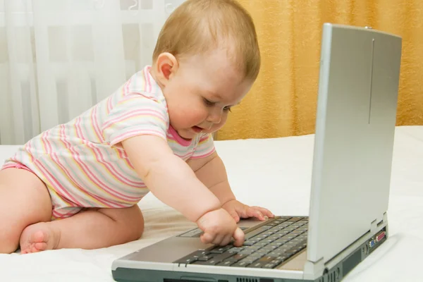 Маленький ребенок и ноутбук — стоковое фото