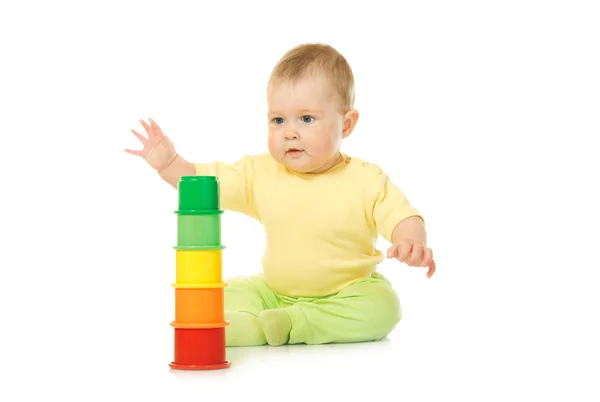 Bebê pequeno com uma pirâmide de brinquedos isolada — Fotografia de Stock