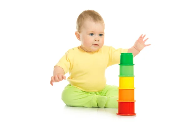 Маленький ребенок с изолированной игрушечной пирамидой — стоковое фото