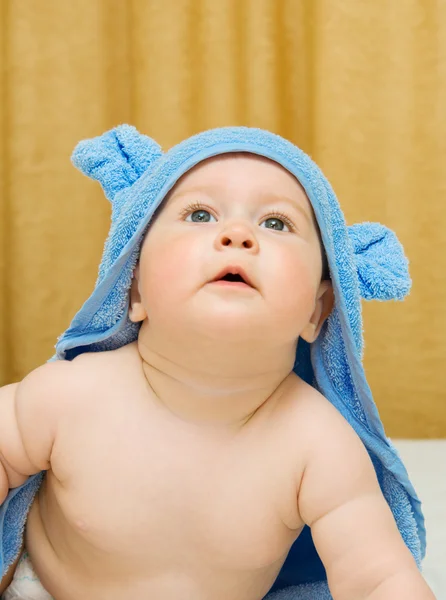 Liten leende bebis i blå handduk — Stockfoto