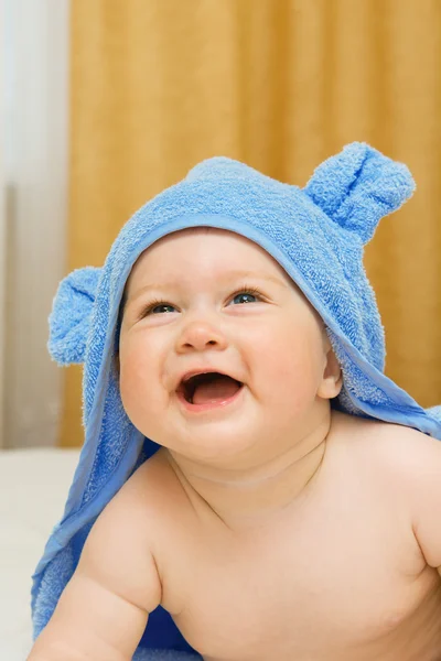 Liten leende bebis i blå handduk — Stockfoto