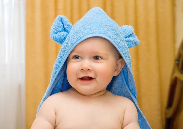 Kleine glimlachende baby blauwe handdoek in — Stockfoto