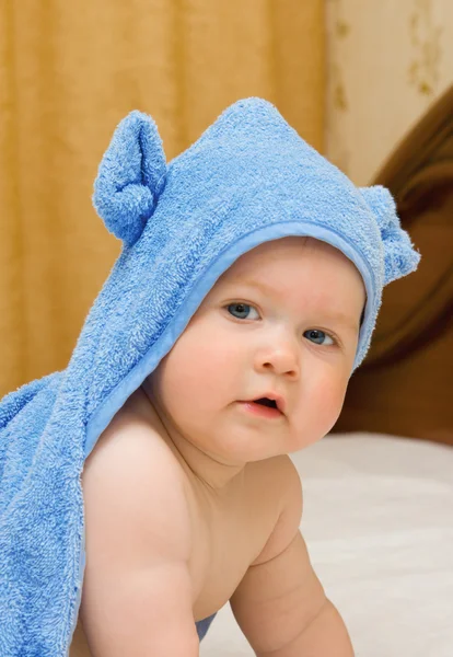 Ребенок в голубой игрушке на кровати — стоковое фото