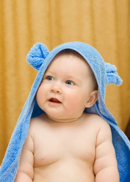 Ребенок в голубой игрушке на кровати — стоковое фото