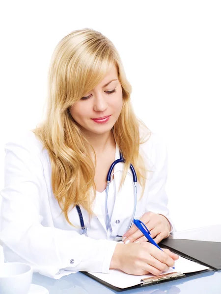 Uśmiechający się blond kobieta lekarz robiąc notatki — Zdjęcie stockowe