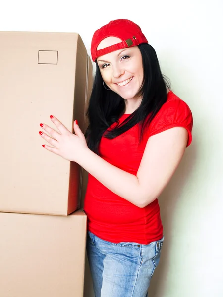 Pretty woman picking up boxes — Stock Photo, Image