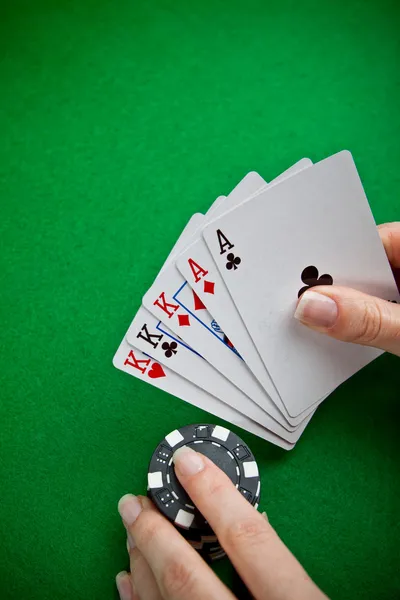 Pokerkaarten en vrouwelijke hand weddenschappen — Stockfoto