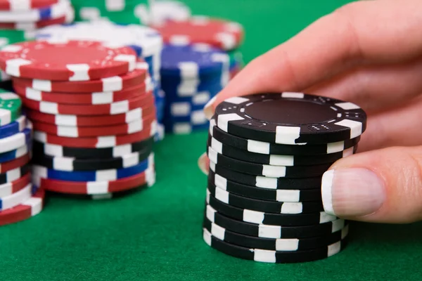 Mão com fichas de poker preto — Fotografia de Stock