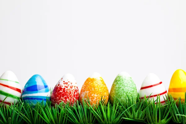 Velikonoční vejce v zelené trávě izolovaných na bílém bac — Stock fotografie