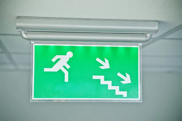 Аварийный выход вниз по лестнице зеленый знак — стоковое фото