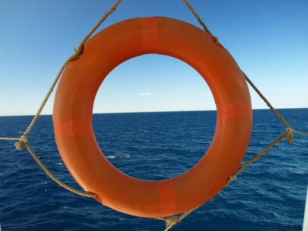 Оранжевое кольцо безопасности против морского бэкграунда — стоковое фото