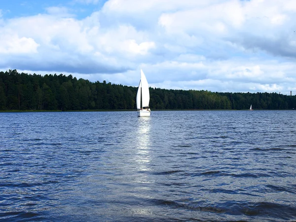 stock image Sailboat sailing on blue cloudy sky