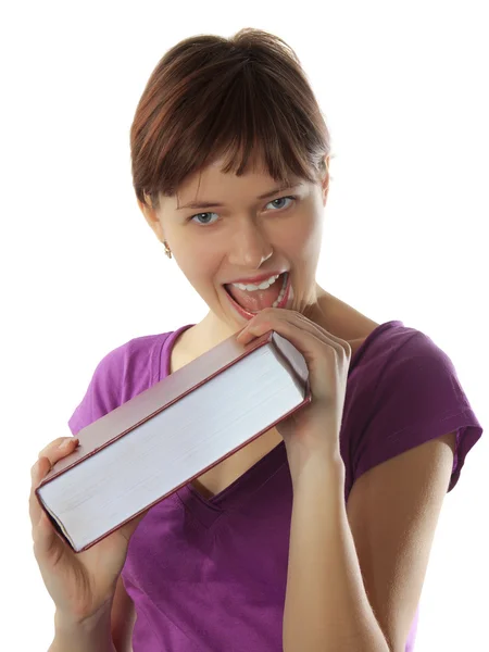 Young nice girl bites the thick book — Stock Photo, Image