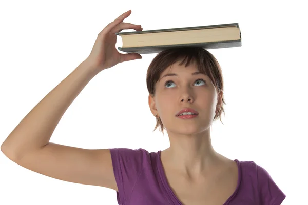 Beautiful girl holds book on a head — Stock Photo, Image