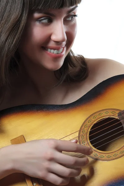 Trevlig tjej spelar en akustisk gitarr Royaltyfria Stockbilder