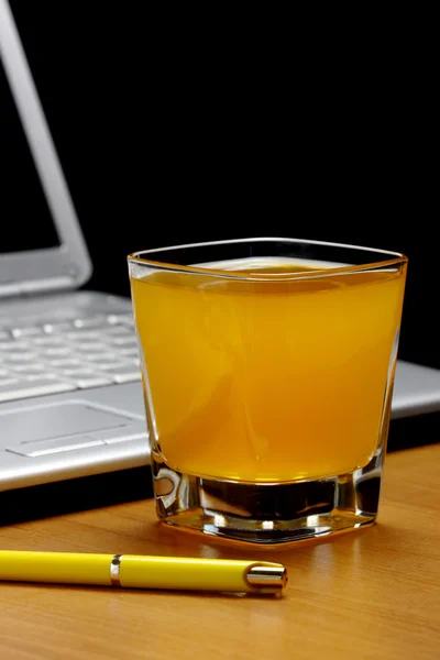 Sumo de laranja, laptop e caneta . — Fotografia de Stock