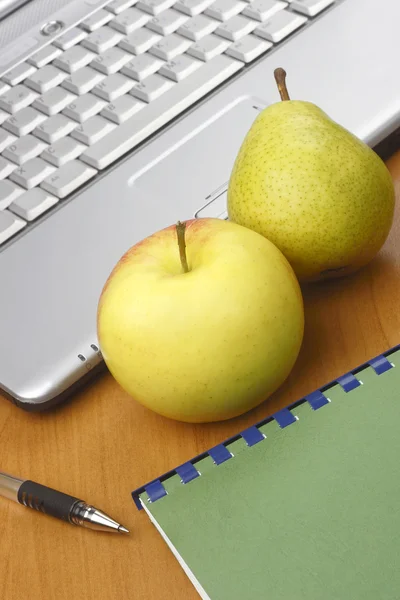 Jablko, hruška a notebook. — Stock fotografie