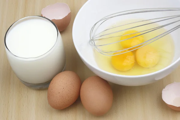 Eieren en melk op houten tafel — Stockfoto
