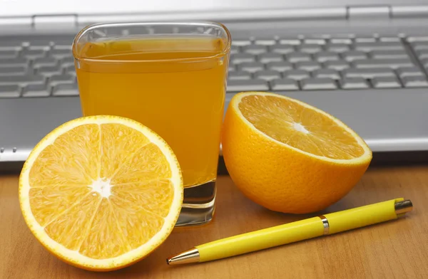 Apelsiner, juice och laptop. — Stockfoto