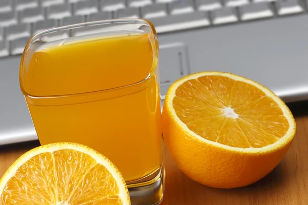 Πορτοκάλια, χυμό και φορητό υπολογιστή. — Φωτογραφία Αρχείου