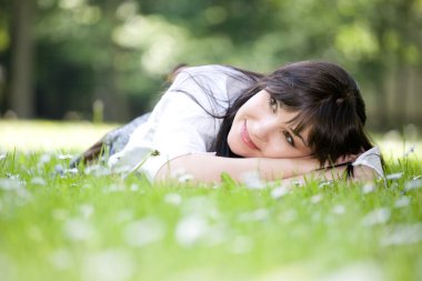 Woman lying on grass clipart