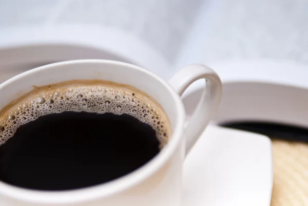 Чашка кофе и открытая книга — стоковое фото