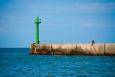 Two fishermans on the breakwater