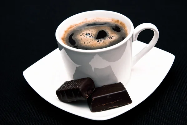 Šálek kávy a čokoládové bonbony — Stock fotografie