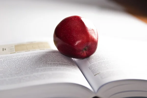 Libro fuerte abierto y manzana roja — Foto de Stock