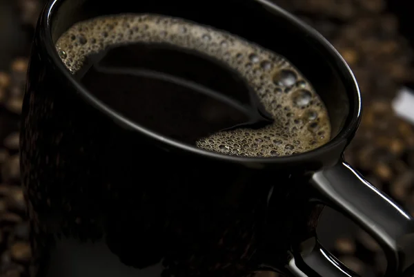 Tasse Kaffee und verstreute Bohnen — Stockfoto