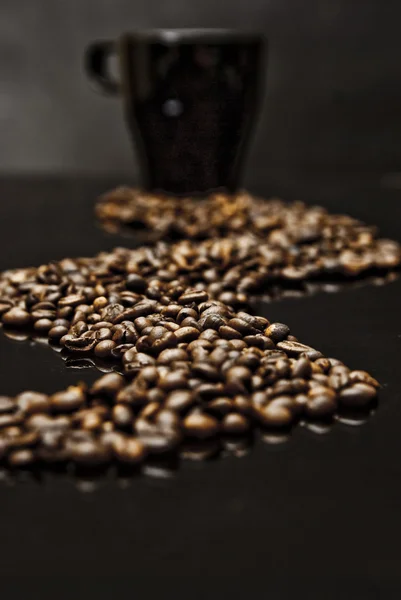 Mok van koffie en verspreide bonen — Stockfoto