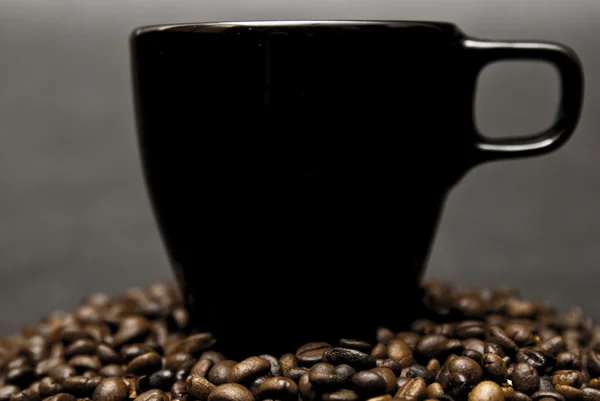 Caneca de café e grãos espalhados — Fotografia de Stock